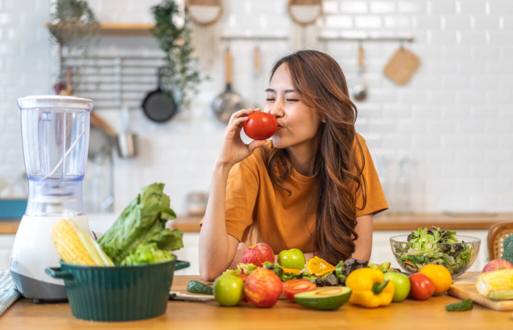 Portrait of beauty health asian woman having fun hold tomato cooking, vegan food healthy eat, fresh vegetable, Lycopene, vitamins, skincare, vegetarian in kitchen.Diet.Fitness, healthy food